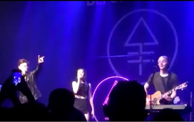 Christina Grimmie's band giving the 'devils horn' and its logo in the background, the alchemical symbol for phosphorous, which is commonly associated with Lucifer in occult circles. 