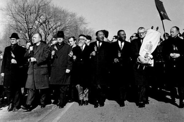 Rabbi Abraham Joshua Heschel guides Dr. Martin Luther King Jr. in the 1965 March on Selma.  In fact, there are only two black men in the picture.