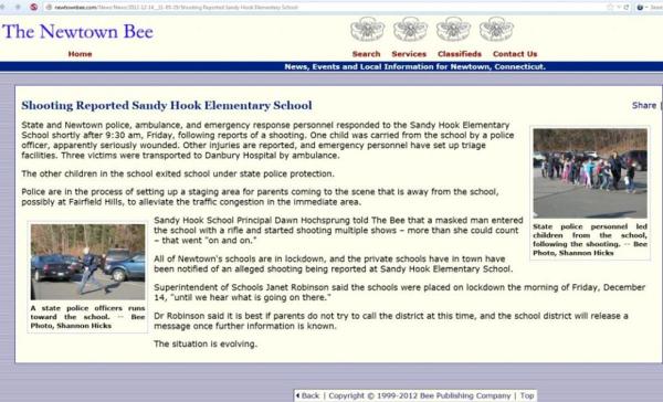A copy of the Newtown Bee which has the interview of the dead principal, Dawn Hochsprung and the fake picture in the upper right-hand corner.  Under the photograph it says, “State police personnel led children from the school, following the shooting,--Bee Photo, Shannon Hicks.”
