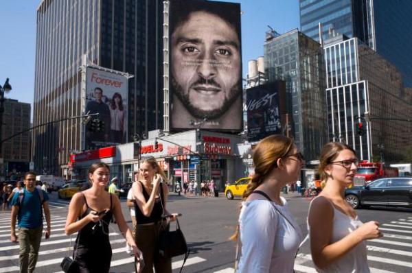 People walk by a Nike advertisement featuring Colin Kaepernick.