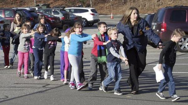 Cropped photograph taken by Shannon Hicks, police and teachers lead children away from Sandy Hook Elementary on Friday, Dec. 14.