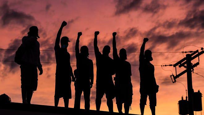 Protestors raise right-handed fist. Are they Communists too?