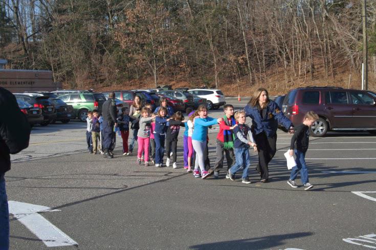 If you look at the entire photograph you will notice that there are more people that were there that were trimmed out of the picture.  Notice, also, that the cars are painted with different colors, i.e. green, red, white, blue, etc.  There were supposedly 469 students.  Why were there no other pictures of other students being led to safety?